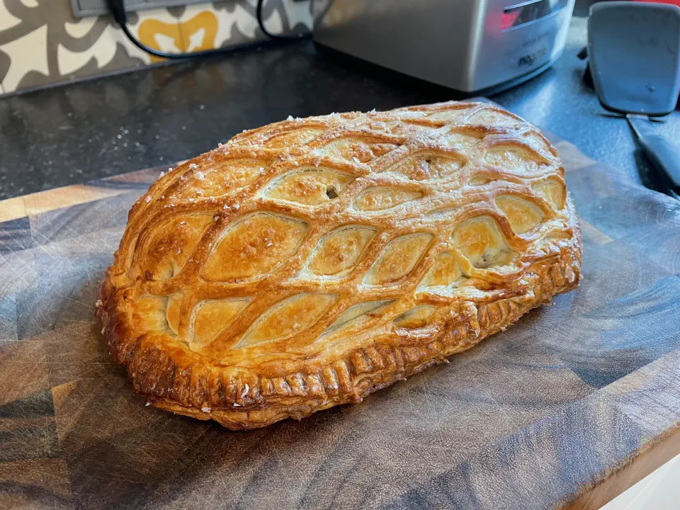 The finished Beef Wellington, sliced to reveal a ruby-pink fillet ringed with dark mushroom duxelles and golden pastry